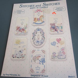 May include: A sheet featuring cross-stitch designs for light switch covers. The designs include a rocking horse, teddy bear, lamb, and bunny, with space for a name and date. The text "Stitches and Switches" and "Soft 'N' Cuddly" are visible.