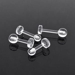 May include: A collection of three clear, transparent acrylic labret studs. Each piece features a flat circular disc base at one end and a spherical ball at the other, with visible screw threading on the post for secure attachment and closure.