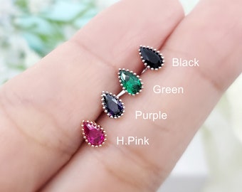 May include: Four teardrop-shaped gemstone earrings in black, green, purple, and hot pink. The earrings are displayed on a hand.