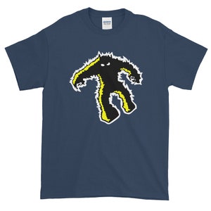 Op de afbeelding: Een marineblauw t-shirt met een zwarte en gele afbeelding van een monster met scherpe tanden en klauwen.