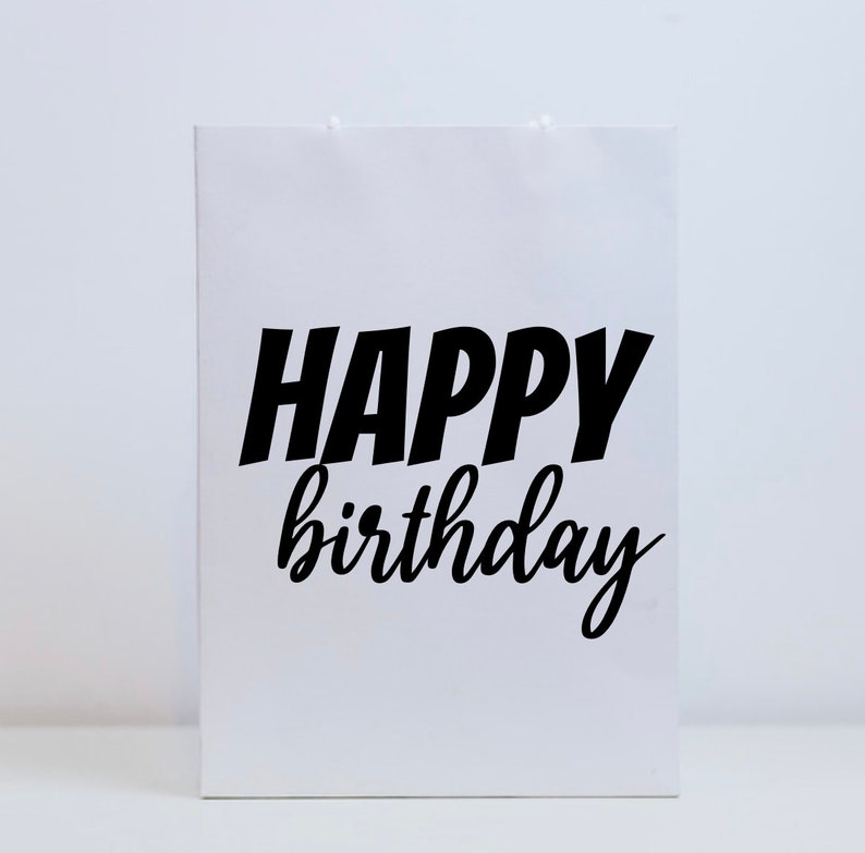 K&ouml;nnte beinhalten: Wei&szlig;e Geschenkt&uuml;te mit schwarzem Text, der "Happy Birthday" lautet.
