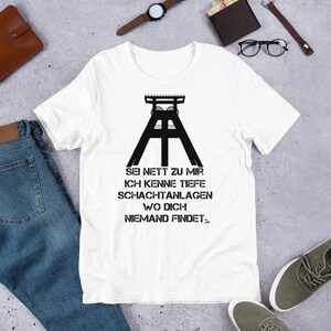 Peut inclure: T-shirt blanc avec un graphique noir d'un puits de mine et le texte "Sei nett zu mir ich kenne tiefe Schachtanlagen wo dich niemand findet."
