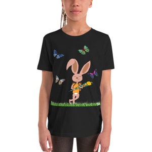 May include: Black youth t-shirt with a cartoon bunny holding a colorful cone and surrounded by butterflies. The bunny is wearing a yellow shirt and brown shorts.