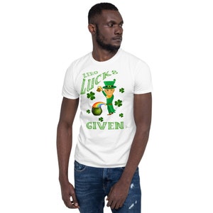 Könnte beinhalten: Weißes T-Shirt mit einem grünen Kobold-Motiv und dem Text "Zero Lucks Given".