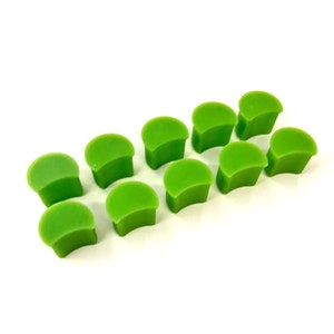 May include: Ten bright green plastic furniture feet, shaped like a half-circle, designed to protect floors from scratches.