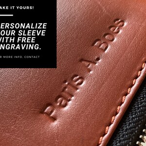 Puede incluir: Primer plano de una funda de cuero marr&oacute;n con cremallera. La funda tiene el texto "Paris A. Boes" grabado en relieve. El texto "MAKE IT YOURS! PERSONALIZE YOUR SLEEVE WITH FREE ENGRAVING. FOR MORE INFO. CONTACT US" es visible en el fondo.