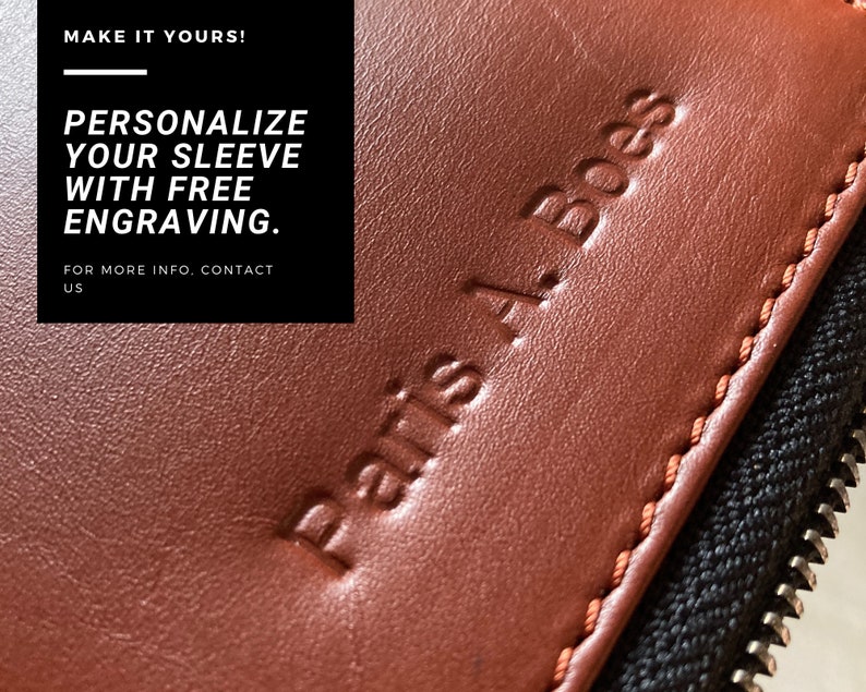 Puede incluir: Primer plano de una funda de cuero marr&oacute;n con cremallera. La funda tiene el texto "Paris A. Boes" grabado en relieve. El texto "MAKE IT YOURS! PERSONALIZE YOUR SLEEVE WITH FREE ENGRAVING. FOR MORE INFO. CONTACT US" es visible en el fondo.