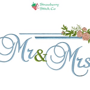 May include: Embroidered design featuring the words "Mr & Mrs" in a light blue cursive font with a double line above the text. A floral arrangement of pink roses and green leaves is positioned above the right side of the text.