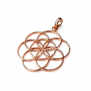 May include: Rose gold pendant with a geometric pattern of overlapping circles. The pendant has a loop for a chain. The design is symmetrical and made of thin metal. The pendant's design is reminiscent of the Flower of Life.