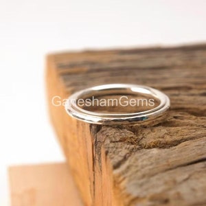 Op de afbeelding: Een zilveren gehammerde ring met een gladde, gepolijste afwerking. De ring is gemaakt van twee banden die iets van elkaar zijn verschoven.