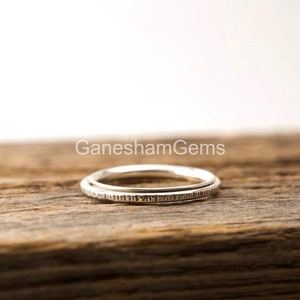 May include: Two silver rings stacked on top of each other. The rings are both thin and have a textured surface.