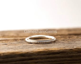 May include: Two silver rings stacked on top of each other. The rings are both thin and have a textured surface.