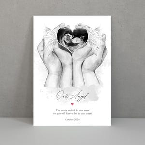 Puede incluir: Un dibujo en blanco y negro de dos manos sosteniendo una imagen de ultrasonido en forma de coraz&oacute;n con alas de &aacute;ngel. El texto "Our Angel" est&aacute; escrito en cursiva con un peque&ntilde;o coraz&oacute;n rojo debajo. El texto debajo dice "You never arrived in our arms, but you will forever be in our hearts. October 2024."