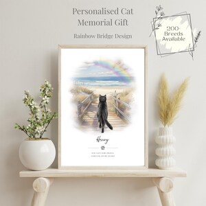 Puede incluir: Un cuadro enmarcado con el texto "Personalised Cat Memorial Gift" y "Rainbow Bridge Design". La obra de arte representa un gato negro caminando por un camino de madera hacia un arcoíris sobre el mar. El nombre del gato, "Henry", está debajo.