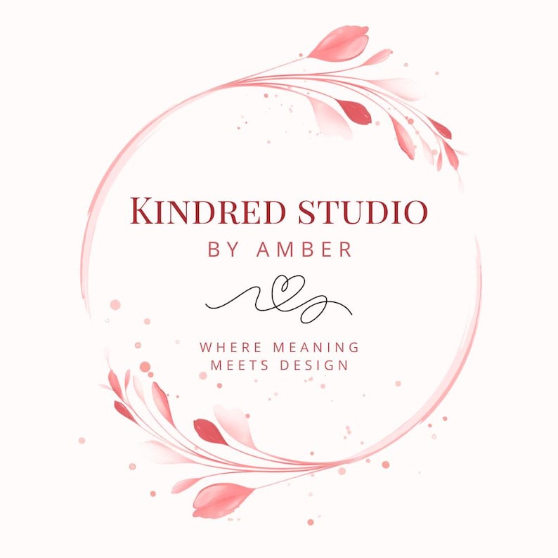 以下が含まれることがあります： Kindred Studio by Amberのロゴ。水彩画風のピンクの花柄アクセントをあしらった円形デザイン。スタジオ名、名前「Amber」、そして「Where Meaning Meets Design」というキャッチコピーが含まれています。