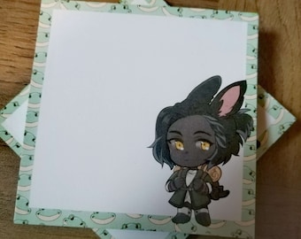 May include: A white notepad with a green border featuring a cartoon character with black fur, yellow eyes, and a brown backpack. The character is wearing a black coat and has bunny ears.