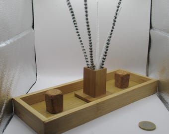 May include: A wooden tray with three cork stoppers and a wooden stand with five black and white striped pipe cleaners.
