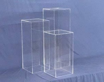 May include: Three clear acrylic display risers of varying heights. The risers are square and have a polished finish.