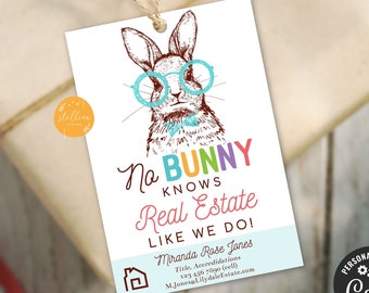 May include: A white tag with a cartoon bunny wearing glasses and a bow tie. The tag says "No bunny knows real estate like we do!" with the words in different colors. The tag also includes a business card with the name Miranda Rose Jones, title, phone number, and website.