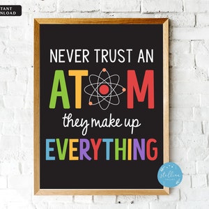 May include: A black chalkboard with a white frame, featuring a colourful graphic that reads "Never trust an atom, they make up everything". The graphic includes a stylised atom with a red nucleus and a white background.