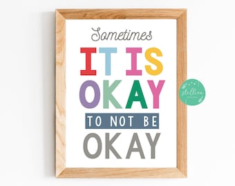 May include: A framed print with the text "Sometimes it is okay to not be okay" in colorful letters. The text is in a white frame with a light wood finish.