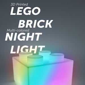 Könnte beinhalten: 3D-gedrucktes mehrfarbiges LEGO-Stein-Nachtlicht. Das Licht ist in Form eines LEGO-Steins geformt und leuchtet in einem Regenbogen von Farben.