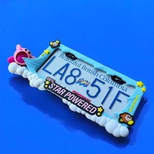 May include: A decorative license plate featuring the text "LA8 51F" and "Beautiful British Columbia". The plate is surrounded by a light blue frame with cartoon characters and the words "STAR POWERED".