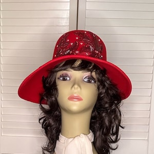 May include: A red felt hat with a wide brim and a decorative design of red sequins and beads on the crown.