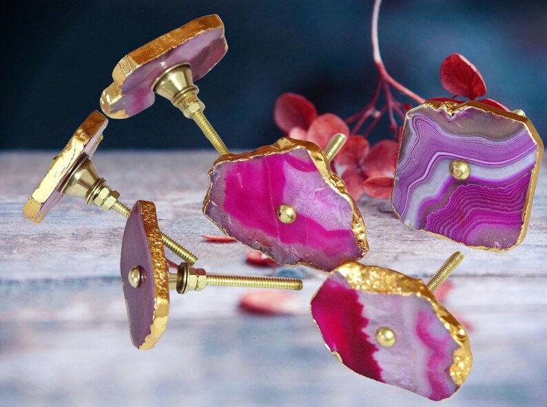 May include: Five agate drawer pulls with gold trim. Each pull features a unique pink and white agate pattern with a gold knob.