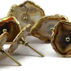 Pode incluir: Conjunto de quatro puxadores de gaveta de &aacute;gata com detalhes dourados. Cada puxador apresenta um padr&atilde;o de &aacute;gata natural &uacute;nico e uma ma&ccedil;aneta de metal dourado.