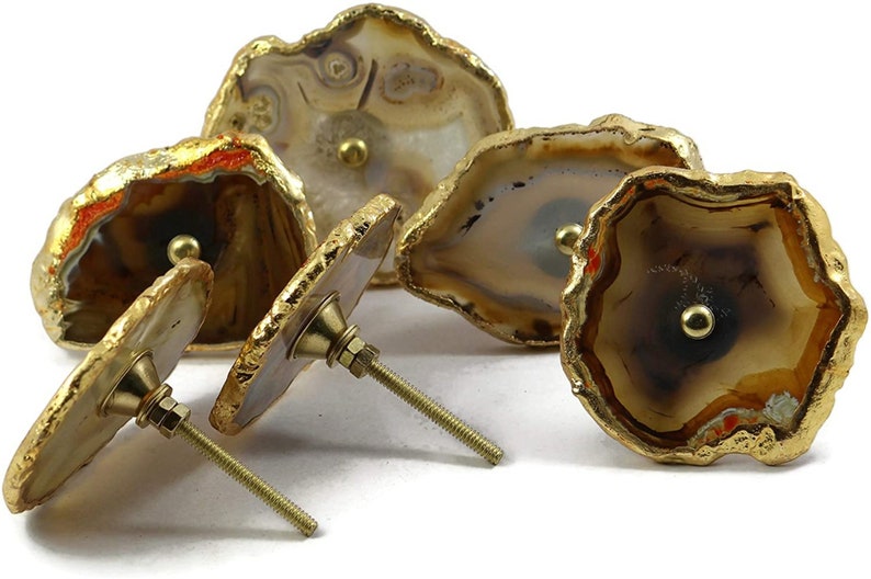 Pode incluir: Conjunto de quatro puxadores de gaveta de &aacute;gata com detalhes dourados. Cada puxador apresenta um padr&atilde;o de &aacute;gata natural &uacute;nico e uma ma&ccedil;aneta de metal dourado.
