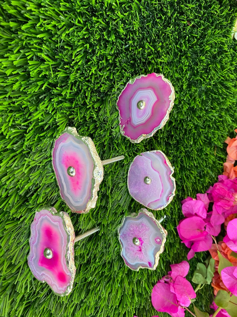 May include: Five pink and purple agate drawer pulls with gold trim. Each pull has a silver knob in the center.