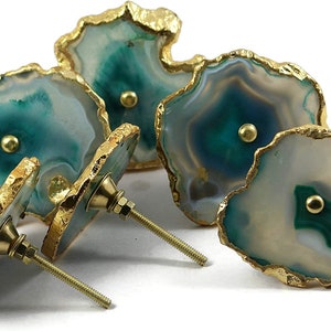 May include: Set of four agate drawer pulls with gold trim. Each pull features a unique green and white agate pattern with a gold screw.