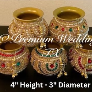 Può includere: Set di quattro vasi decorativi dorati con decorazioni di perle e pietre preziose. Ogni vaso è alto 10 cm e ha un diametro di 7,6 cm.