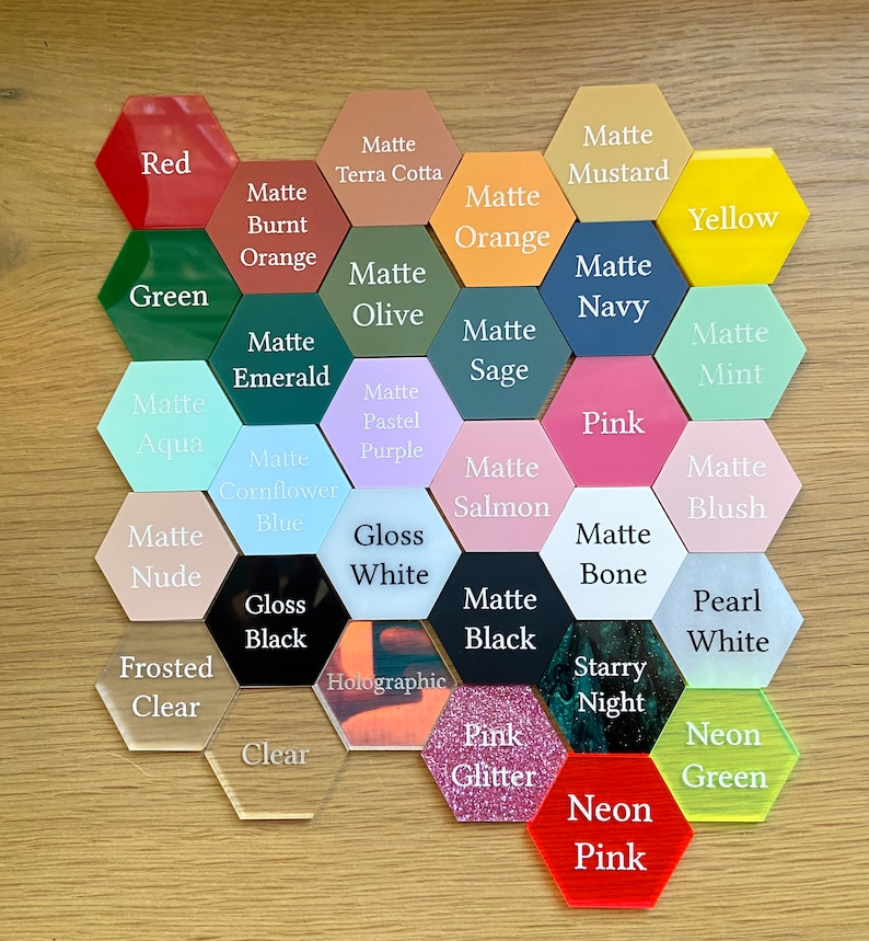 May include: A variety of hexagon-shaped acrylic blanks in different colors and finishes, including matte, gloss, holographic, and neon. The colors include red, green, yellow, blue, pink, purple, orange, white, black, and brown. The finishes are labeled with text.