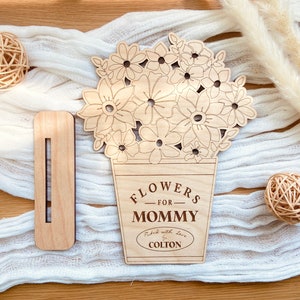 Op de afbeelding: Houten uitsnijding van een boeket bloemen in een pot met de tekst "Flowers for Mommy" en "Picked with love by Colton".