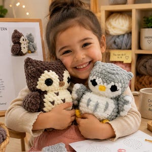 Peut inclure: Une jeune fille souriante tient deux chouettes en crochet. L'une est marron et crème, l'autre grise et blanche. Un patron de chouette, de la laine et une tasse avec "Crochet Create Repeat" sont visibles. Les chouettes sont faites à la main.