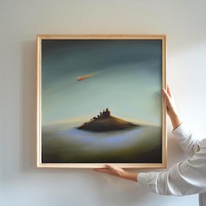 Peut inclure: Une peinture carrée encadrée représentant un ciel sombre et nuageux avec une petite traînée de lumière orange au-dessus d'une colline ou d'une île isolée. L'œuvre est insérée dans un cadre en bois clair au bord simple et épuré.