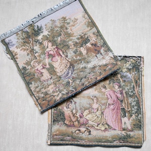 May include: Two rectangular tapestries with pastoral scenes. One depicts figures in 18th-century attire in a forest setting, the other shows a similar scene with a seated musician and a dog. The tapestries have a fringed edge and are made in France.