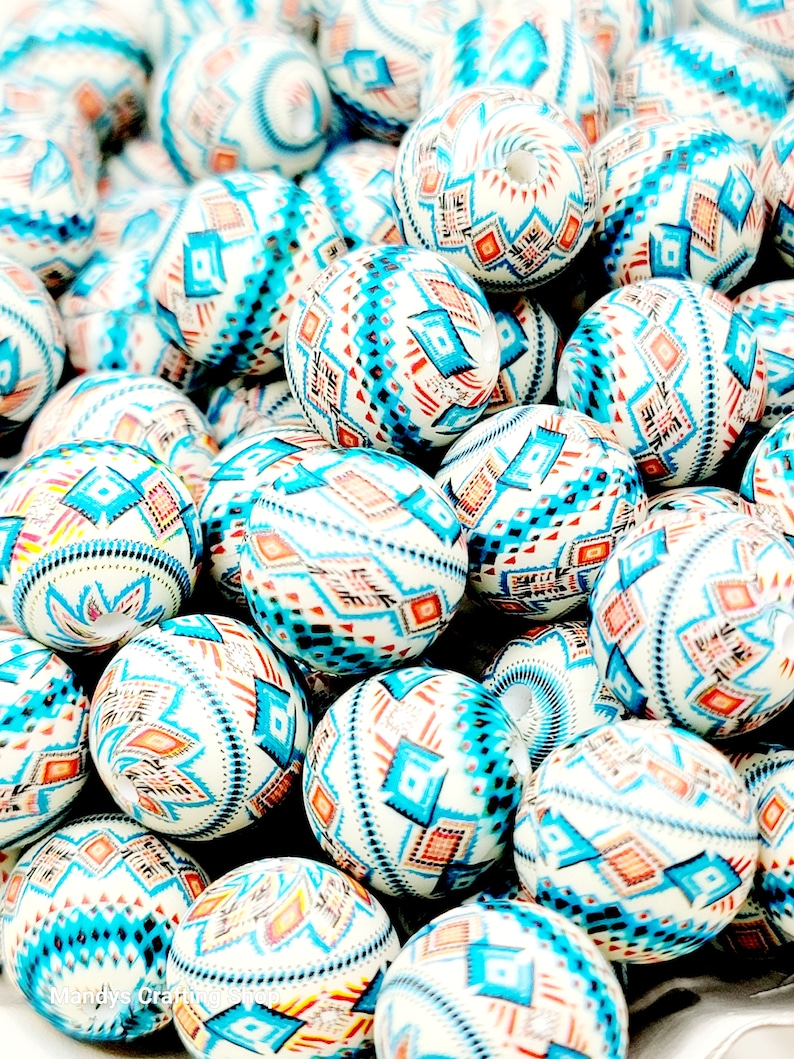 May include: A close-up of a pile of white, blue, and orange round beads with a geometric pattern. The beads are made of plastic or ceramic and are perfect for jewelry making.