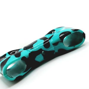 May include: A teal and black patterned object with a curved design. The object has a glossy finish and a camouflage-like pattern. The object has two circular openings on either end.