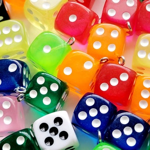 May include: A collection of colorful dice with white dots. The dice are made of clear plastic and have a variety of colors, including red, orange, yellow, green, blue, and pink.