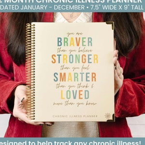 May include: A beige planner with a gold spiral binding. The cover features a motivational quote in colourful letters: "You are BRAVER than you believe STRONGER than you feel SMARTER than you think & LOVED more than you know." The text "CHRONIC ILLNESS PLANNER" is printed below the quote.