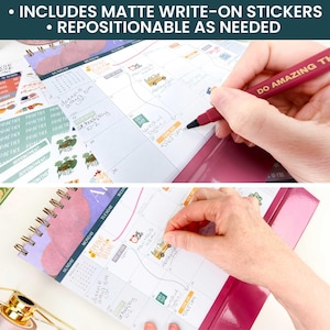 May include: A spiral-bound desk calendar with a purple and white design, featuring handwritten notes and colorful event stickers. The calendar includes matte write-on stickers that are repositionable. A maroon pen with the text DO AMAZING THINGS is visible.
