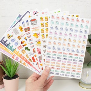 Op de afbeelding: Een set kleurrijke planner stickers met illustraties met een voedselthema en de tekst "embrace 1 pastaibility" en "grill chill". De set bevat ook meerdere stickers met de tekst "meal prep".