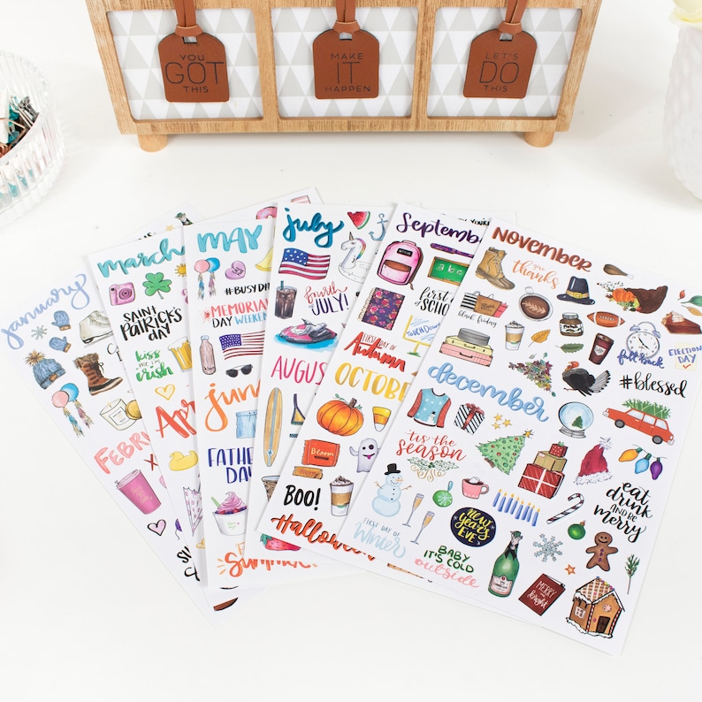 May include: A set of 12 monthly sticker sheets featuring colorful illustrations and handwritten text. Each sheet includes various stickers representing holidays and events for each month of the year. The stickers are perfect for planners, journals, and other creative projects.