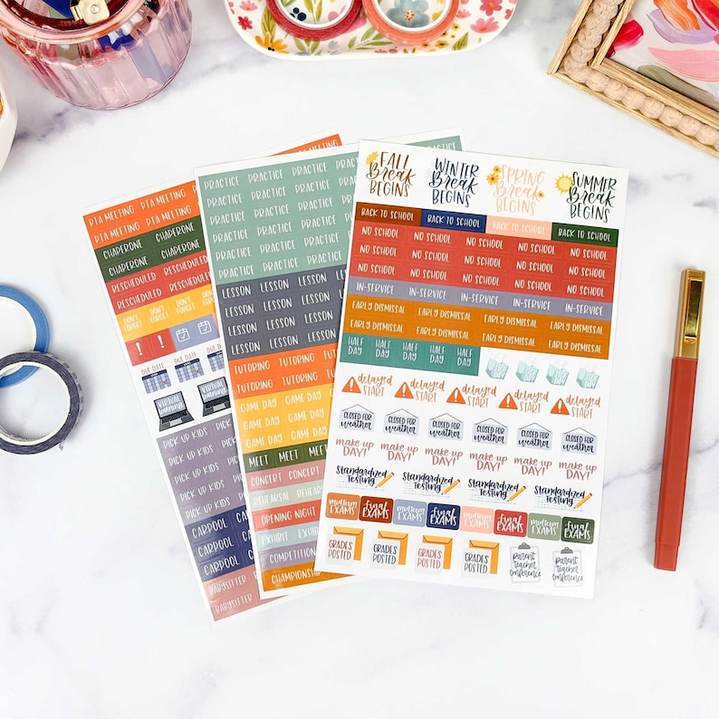 May include: Three sheets of adhesive planner stickers featuring school-related text and icons. The stickers include labels like Fall Break Begins, No School, Early Dismissal, and Tutoring in various colors including orange, green, blue, and red.