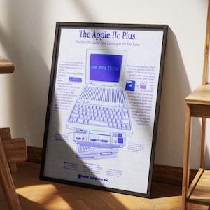 以下が含まれることがあります： ヴィンテージのApple IIc Plusコンピューターの広告が掲載された額入りのポスター。ポスターは黒いフレームで、コンピューターの青と白のイラストが描かれており、画面には「one more thing」というテキストが表示されています。Apple Computer Inc.のロゴが下部にあります。