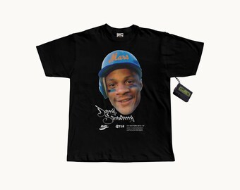 May include: A black short-sleeve t-shirt featuring a graphic of a baseball player wearing a blue helmet with the word Mars in orange. Below the face is the text Darryl Strawberry, the Mars logo, Q718, and New York Mets text. A small black pager is attached.