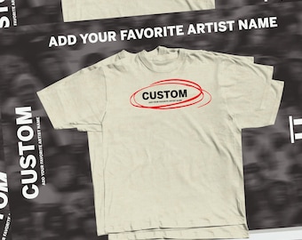 May include: A beige short-sleeved t-shirt featuring a red circular graphic with the black text CUSTOM and the smaller text ADD YOUR FAVORITE ARTIST NAME underneath. The shirt is displayed against a dark background with repeating text.